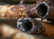 Corroded copper pipe with flaking and rust damage detected by a Colorado plumber